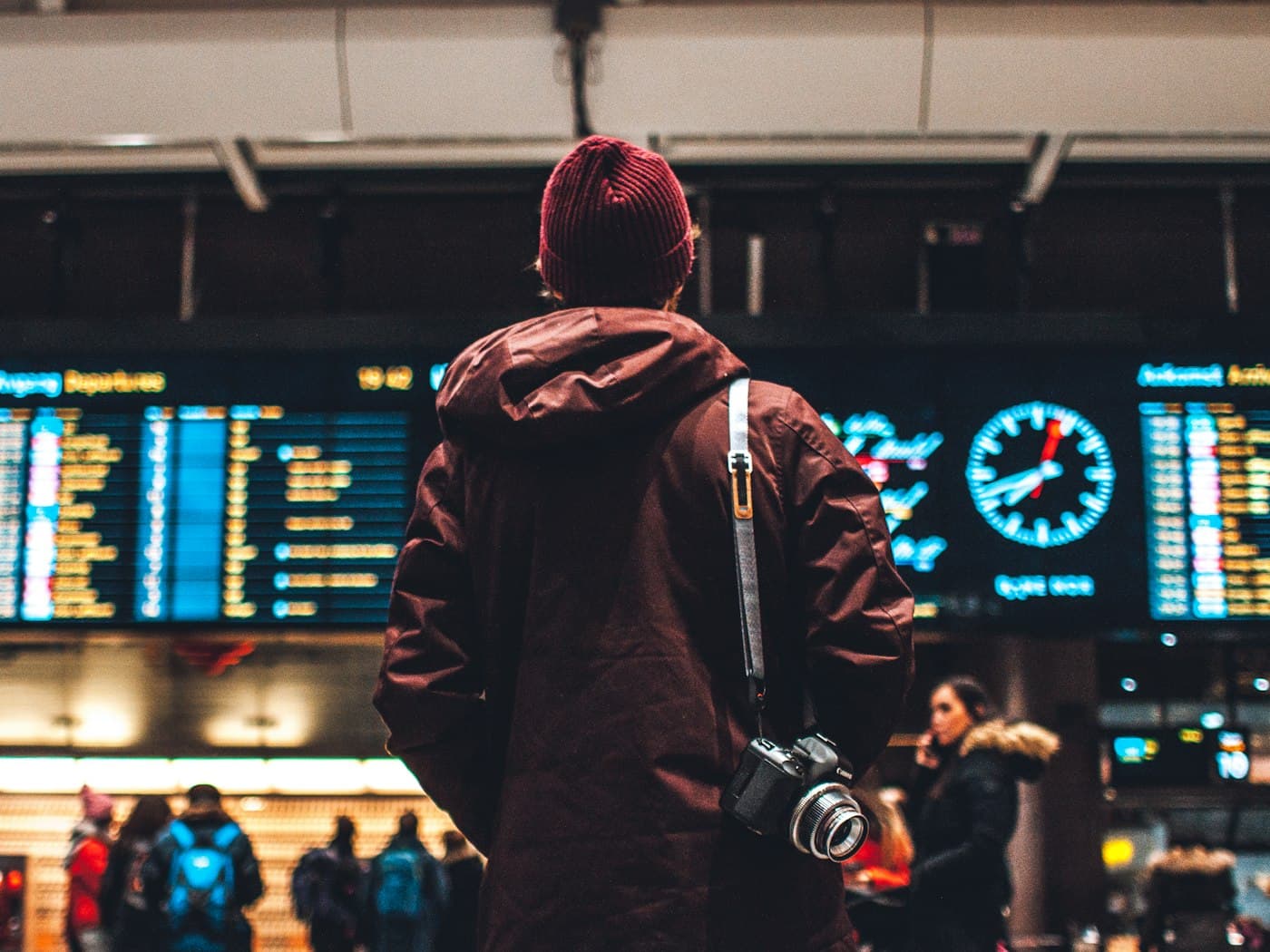 Voyageur consultant le tableau des départs dans un aéroport